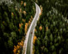 Aerial view of fall road with autumn woods and first snow in Finland.