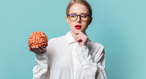 Portrait of beautiful blonde in white shirt with human brain on